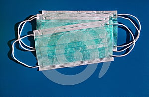 Medical protective green masks activated carbon disposable fiber face on blue background. Face masks that protects against virus.