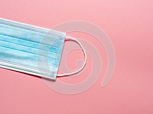 Medical protective mask on a pastel pink background. Individual, disposable surgical face mask. Quarantine healthcare, hygiene and