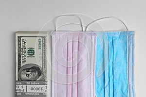 Medical protective masks and a bundle of dollars, money on white background. Surgical face mask. Chinese coronavirus covid-19