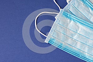 Medical protective three-layer disposable blue masks on a blue background. Protection against viruses and diseases. Close-up
