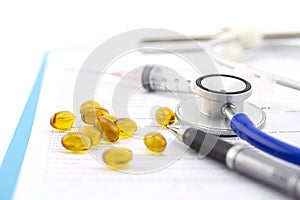 Medical questionnaire, stethoscope, pen and Fish oil capsule