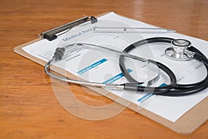 Medical Record on Clipboard with Stethoscope on a Desk