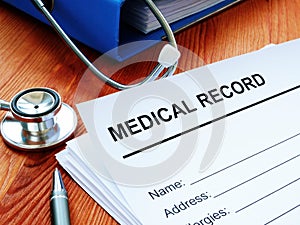 Medical record and stack of papers with stethoscope