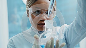 Medical Research Laboratory: Portrait of a Beautiful Female Scientist in Goggles Using Micro Pipette for Test Analysis.