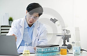 Medical Research Laboratory: Portrait of a Handsome Male Scientist Using Digital Tablet Computer, Analysing Liquid