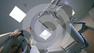 Medical scanning machine is moving upwards during procedure held on a man