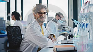 Medical Science Laboratory: Handsome Latin Scientist is Using Microscope, Looking at Camera and