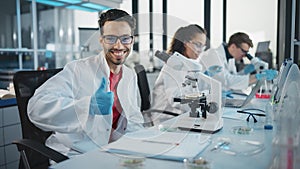 Medical Science Laboratory: Handsome Scientist is Using Microscope for Sample Analysis, Looking at