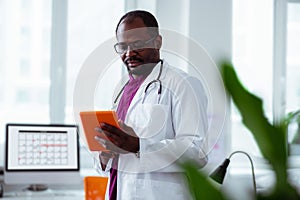 Medical scientist holding orange tablet working in laboratory