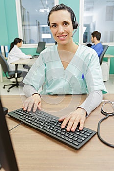 medical secretary typing report on deskop computer