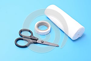 Medical set: a plaster, bandage scissors, isolated on a blue background.