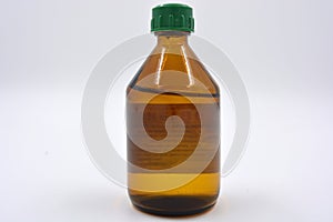 A medical small bottle of medicine with a liquid made of black, brown glass and located on a white background.