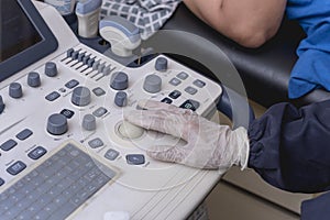 A medical sonographer using the trackball of a ultrasound machine at the clinic