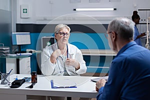 Medical specialist having discussion with patient at annual checkup visit in office