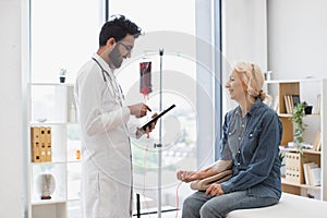 Medical specialist monitoring blood transfusions looking at electronic history.