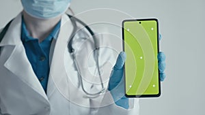A medical specialist uses a smartphone to present medical services and advertise pharmaceuticals. The doctor points his
