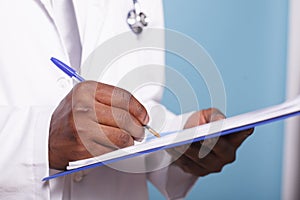 Medical specialist writing on clipboard