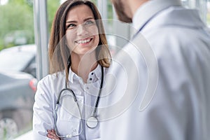 Medical Staff Having Discussion In Modern Hospital Corridor.