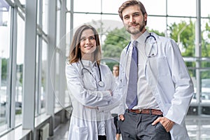 Medical Staff Having Discussion In Modern Hospital Corridor.