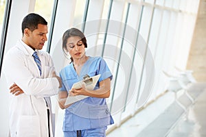 Medical Staff Having Discussion In Modern Hospital Corridor