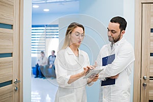 Medical Staff Having Discussion In Modern Hospital Corridor