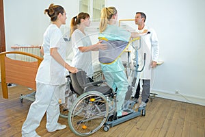Medical staff helping woman to standing photo