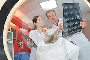 Medical staff looking at xrays viewed from inside mri scanner photo