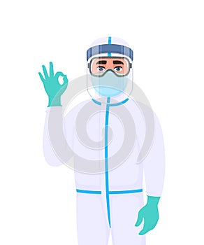 Medical staff in protective suit showing okay, OK gesture sign. Doctor wearing face shield, gloves and gesturing hand. Physician