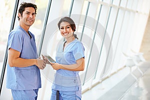 Medical Staff Talking In Hospital Corridor With Digital Tablet photo