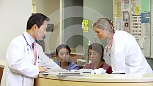 Medical Staff Working At Busy Nurses Station