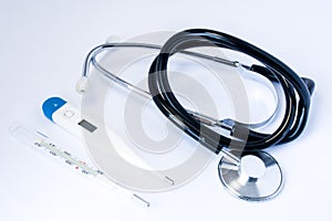 Medical stethoscope with black tubes and two thermometer for measuring temperature of human body: mercurial and digital or electro photo