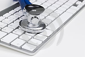 Medical stethoscope on computer keyboard. Concept of computer support.