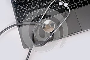 medical stethoscope, the doctor's tool lies on the laptop keyboard, physician's workplace, checking the health