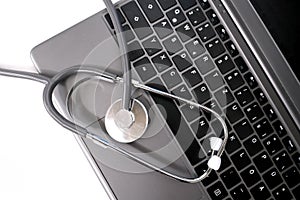 Medical stethoscope, the doctor`s tool lies on the laptop keyboard, the concept of a physician`s workplace, checking the health