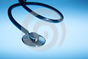 Medical stethoscope dramatically lit against a blue background