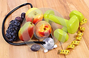 Medical stethoscope, fruits and dumbbells for using in fitness