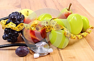 Medical stethoscope, fruits and dumbbells for using in fitness