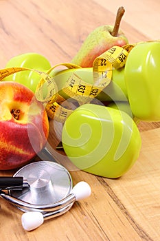 Medical stethoscope, fruits and dumbbells for using in fitness