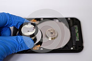 A medical stethoscope on HDD platters and spindle motor, hard disk drive disassembled damaged components, computer maintenance,