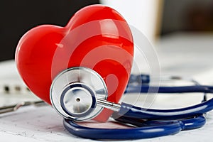 Medical stethoscope head and red toy heart