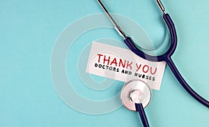 Medical stethoscope and the inscription Thank you to doctors and nurses on a blue background