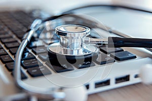 Medical stethoscope on laptop computer keyboard
