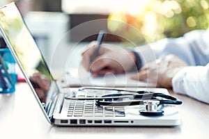 Medical stethoscope on laptop keyboard. Blur background of a doctor reviewing documentation of a patient in consultation