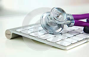 Medical stethoscope lies on a computer keyboard