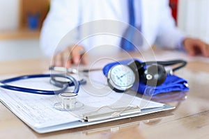 Medical stethoscope lying on cardiogram chart closeup