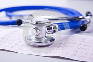 Medical stethoscope lying on cardiogram chart closeup. Medical help, prophylaxis, disease prevention or insurance