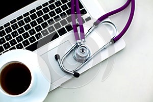 Medical stethoscope lying on a computer keyboard