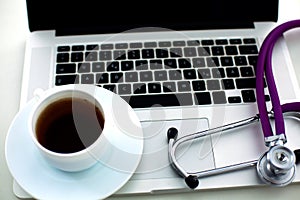 Medical stethoscope lying on a computer keyboard