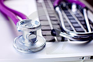 Medical stethoscope lying on a computer keyboard