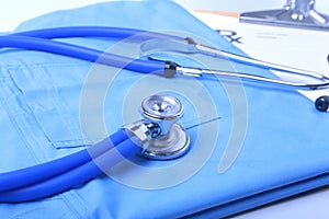 Medical stethoscope lying on patient medical history list, RX prescription and blue doctor uniform closeup. Medical help